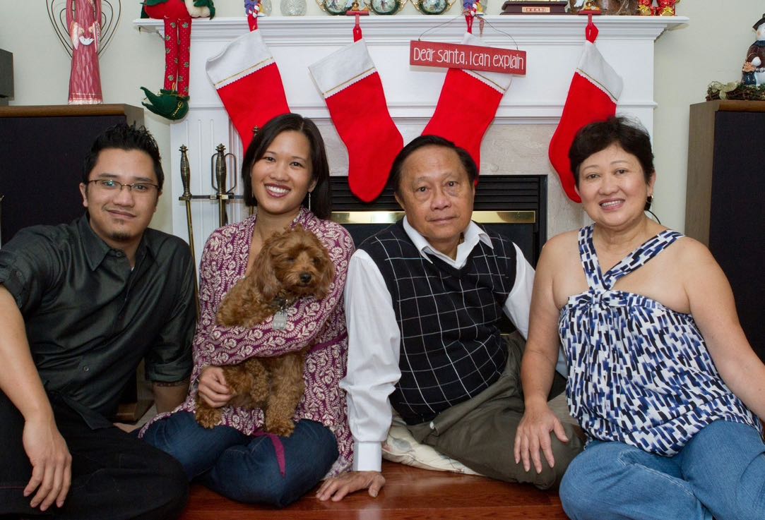 The Chiu family (Chris, Cherrie and their parents Alex and Alicia) sit in front of a fireplace