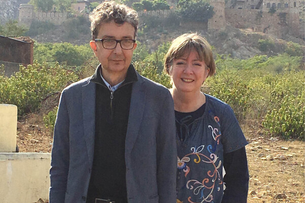 Gerald and Kathy standing side by side. Gerald is on the left in a blue blazer and black sweater, Kathy on the right is in a blue shirt with a floral design.